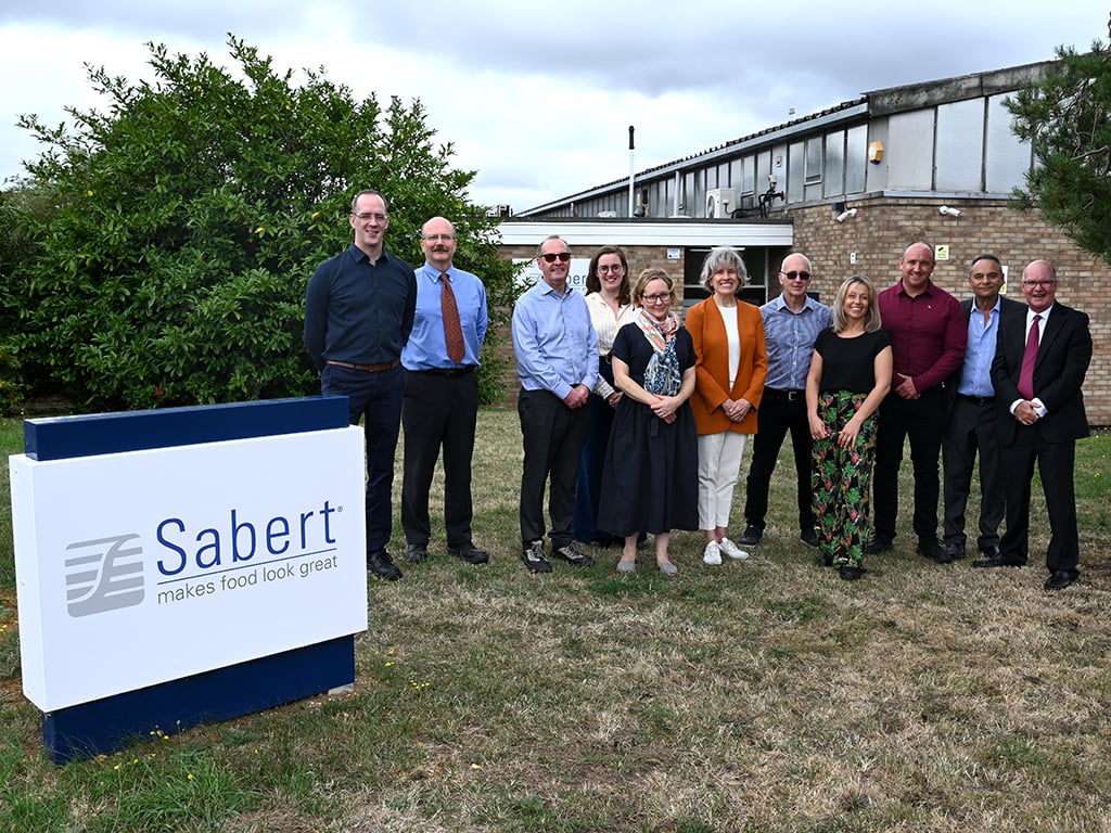 Sabert leadership teams stood in a group outside of Sabert UK offices in Flitwick. Colpac signage in front left foreground and factory site in background.