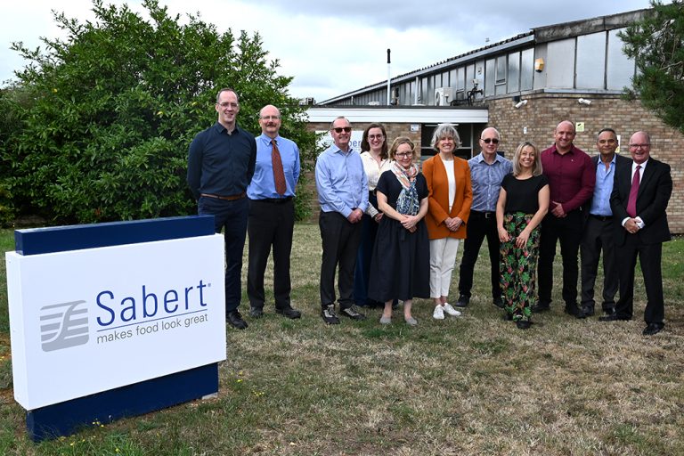 Sabert leadership teams stood in a group outside of Sabert UK offices in Flitwick. Colpac signage in front left foreground and factory site in background.